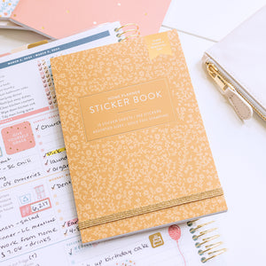Home Planner Sticker Book in yellow along with Home Planner on counter