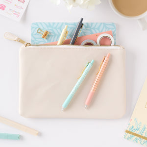 cream zipper pouch with accessories in it