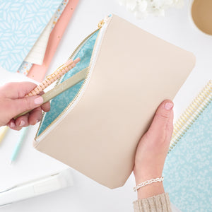 cream zipper pouch with pens in it