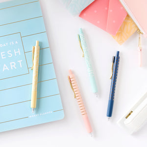 gel pen set on desk with money planner