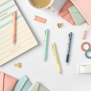 2nd edition gel pens on desk with items