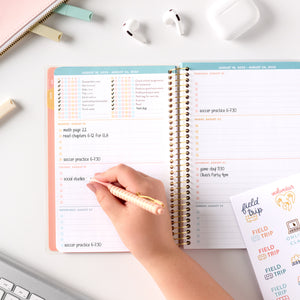 pink student planner being written in