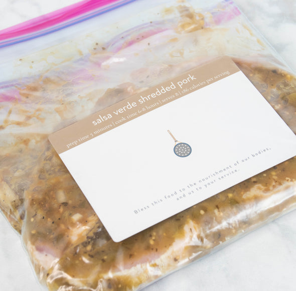 Meal prepped for freezer in plastic zip-top bag with Freezer  Series Baby Card recipe for Salsa Verde Shredded Pork