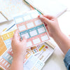Lady holding Home Planner Sticker Book Priorities page