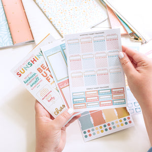 Lady holding sticker pages from Home Planner Sticker Book