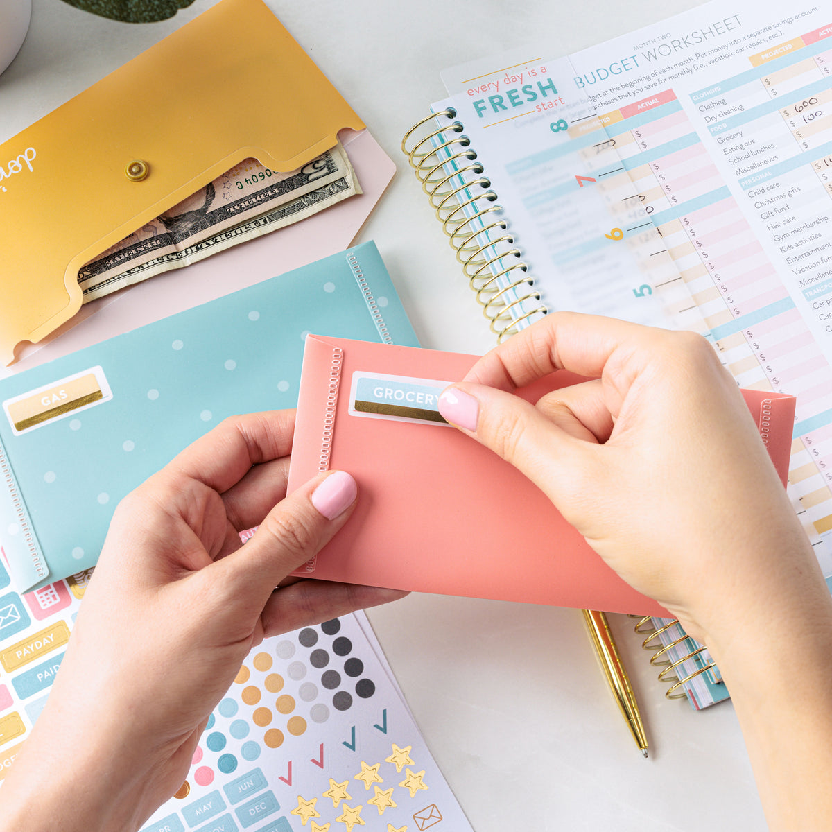 Lady putting stickers on envelopes along with Money Planner 