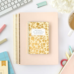 2026 gold floral pocket calendar on top of blush home planner
