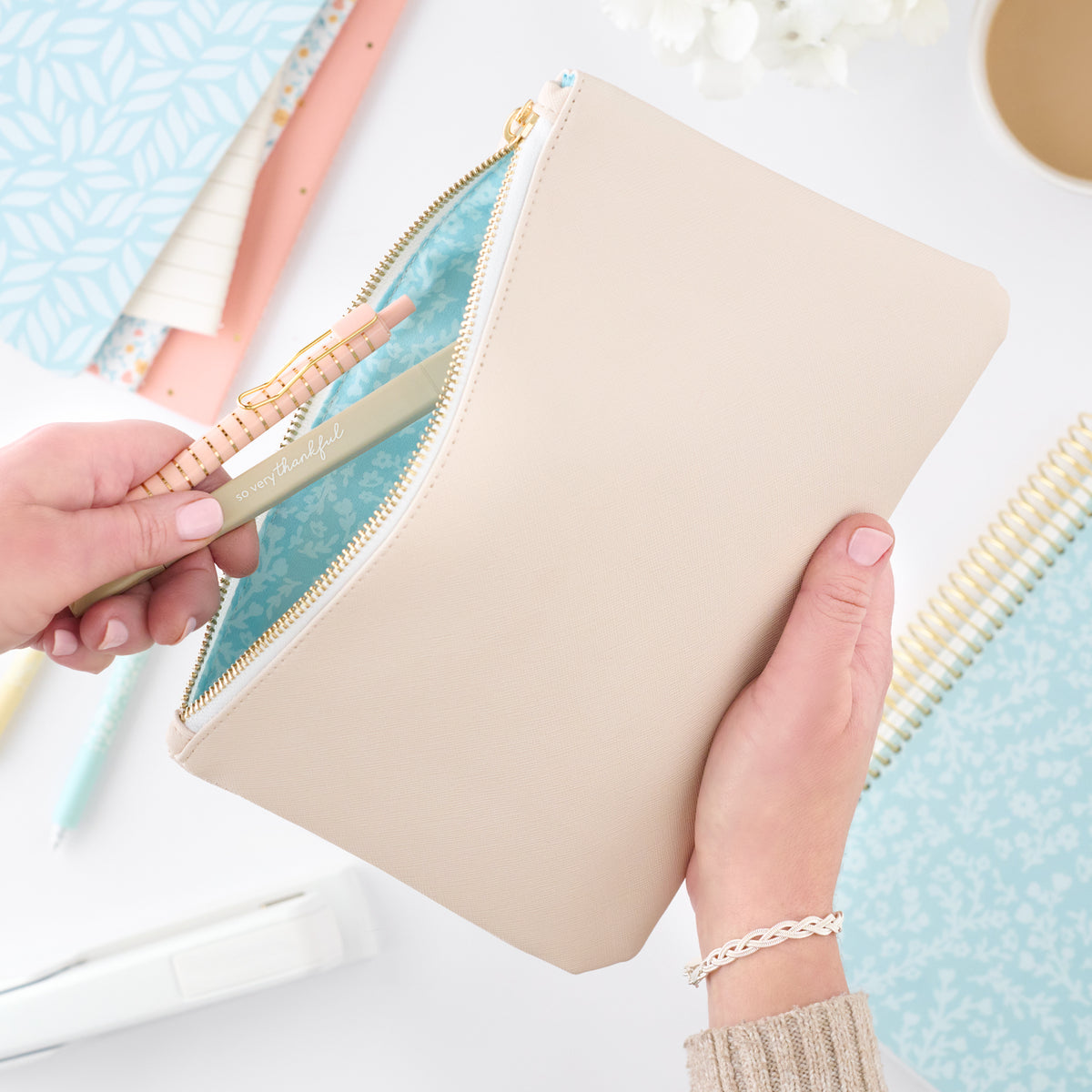 cream zipper pouch with pens in it