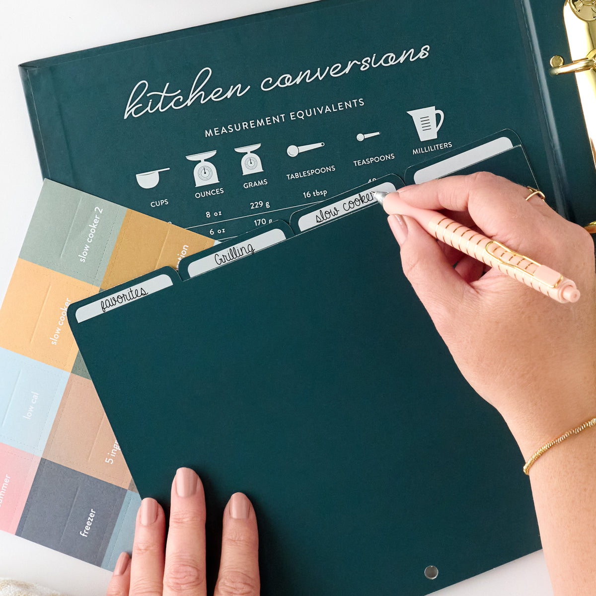 navy recipe binder with tab being written in