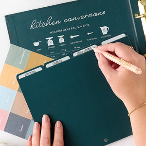 navy recipe binder with tab being written in