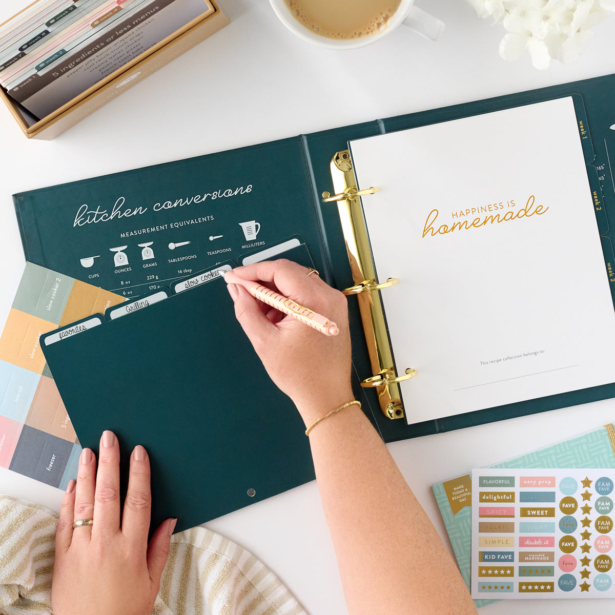 navy recipe binder with person writing on tab