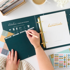 navy recipe binder with person writing on tab